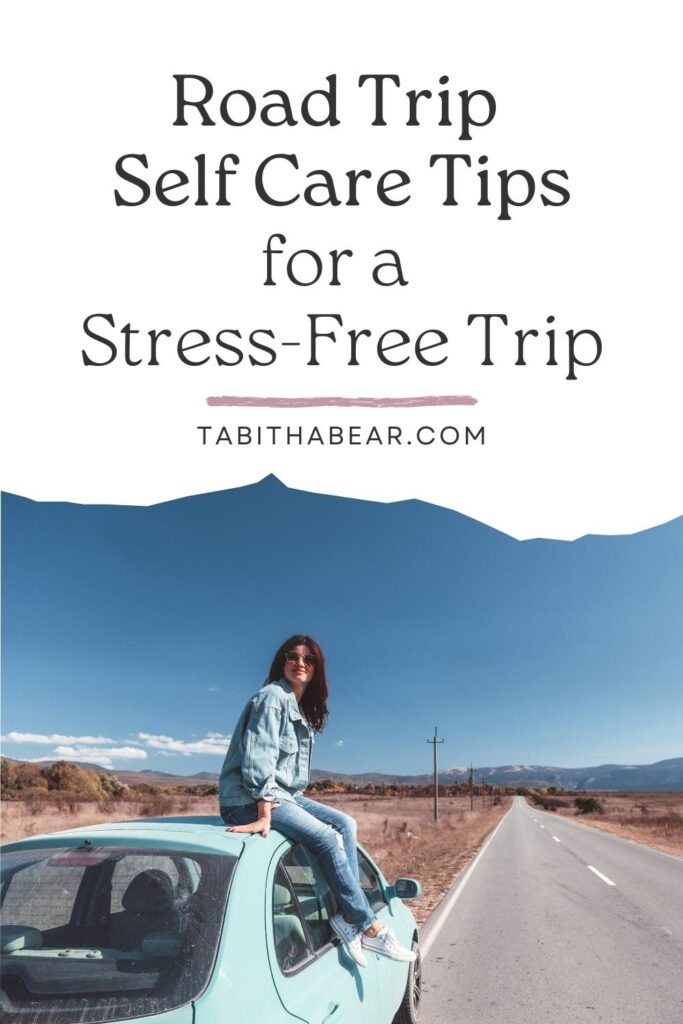 Photo of a woman sitting on top of a car on the side of a road. Text above her reads "Road Trip Self Care Tips for a Stress-Free Trip."