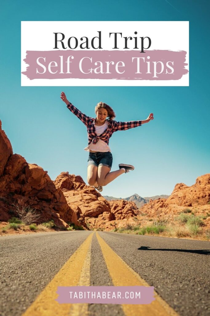 Photo of a woman jumping in the middle of a road. Text above her reads "Road Trip Self Care Tips."