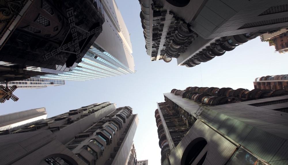 A low-angle view of high-rise buildings that give off a dystopian vibe, an emphasis on Dystopian Romance Novels.