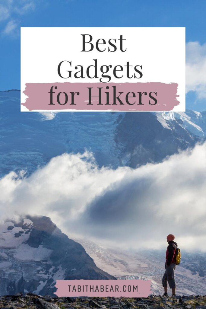 Photo of a person hiking with large snow-capped mountains in the background. Text at the top reads "Best Gadgets for Hikers."