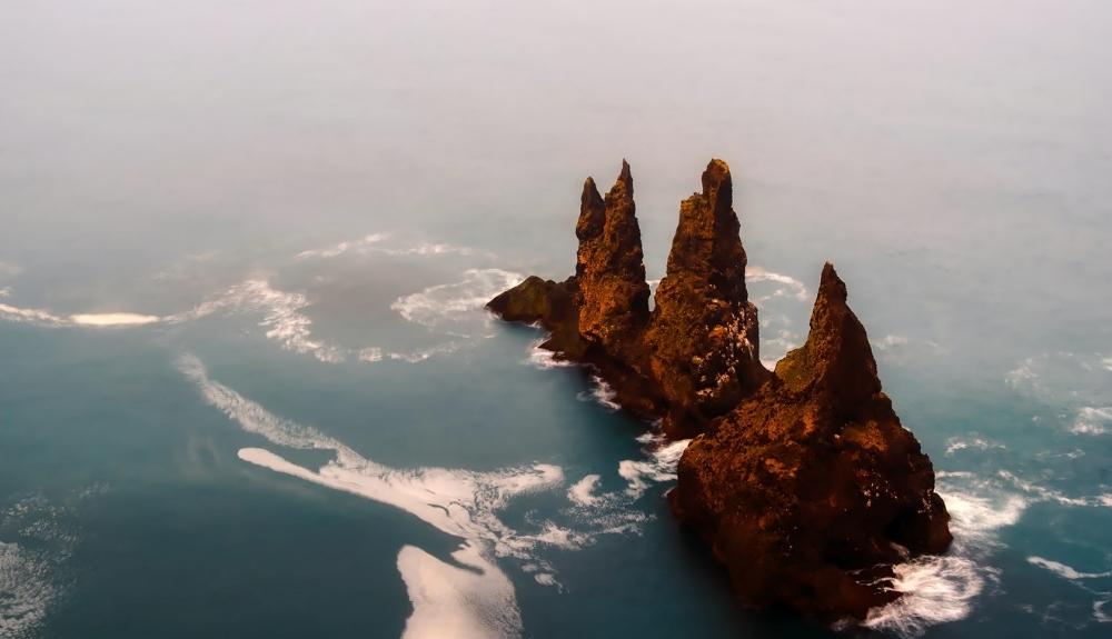 Aerial view of three sea stacks. A trademark of Icelandic coastlines. 