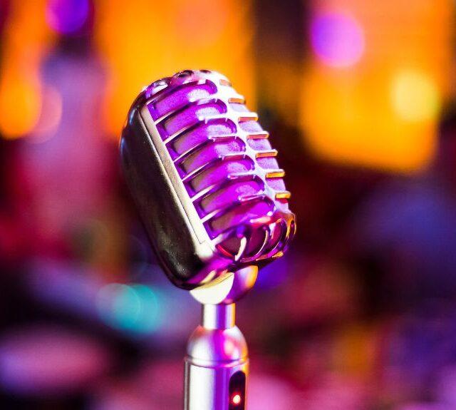 Showing a podcast accessory microphone lit up by a purple light.