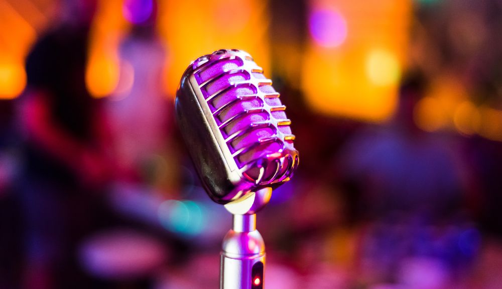 Showing a podcast accessory microphone lit up by a purple light.