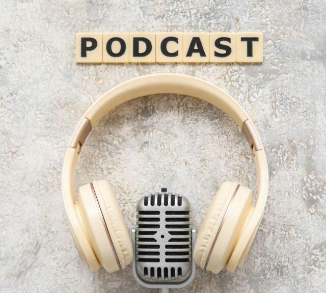 Headphones and microphone with the word podcast.